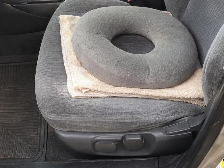 Un asciugamano piegato e una ciambella in gommapiuma sul sedile dell'auto